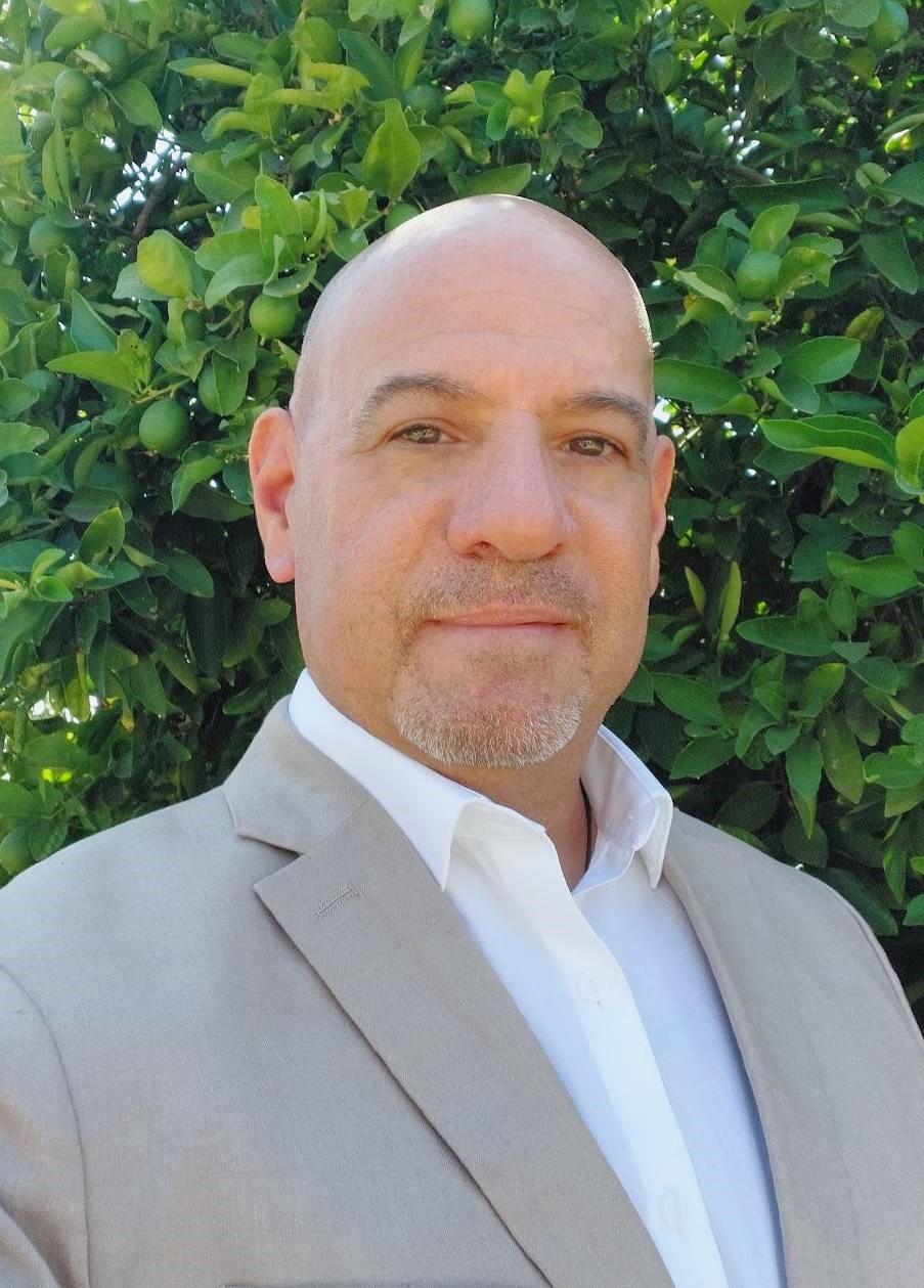 Man wearing a tan suit jacket and white dress shirt