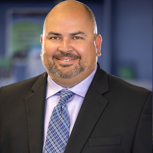 Michael wearing a dark suit with a blue tie